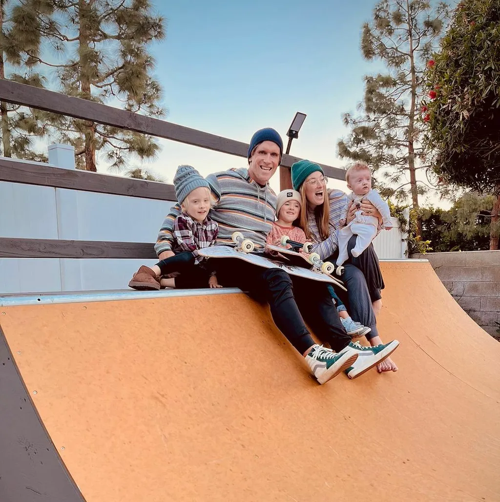 Family with baby smiling and sitting on the coping of a miniramp